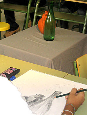 Fotografía de un alumno dibujando un bodegón a lápiz en el aula