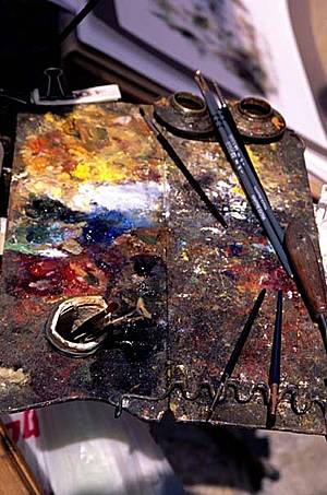 Fotografía de una paleta de pintura con pinceles y óleos
